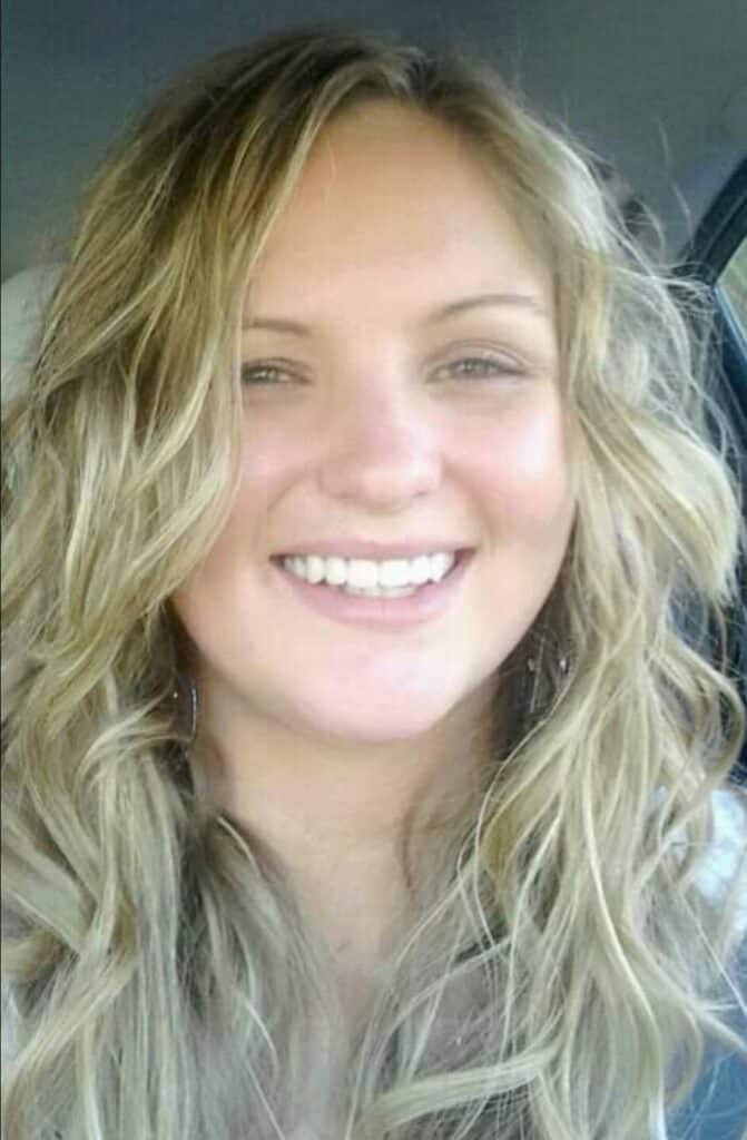 Close-up portrait of a smiling woman (the creator of this blog, Shannon Wheeler) with sun-kissed, wavy blonde hair and subtle makeup, radiating a joyful and relaxed demeanor in a car